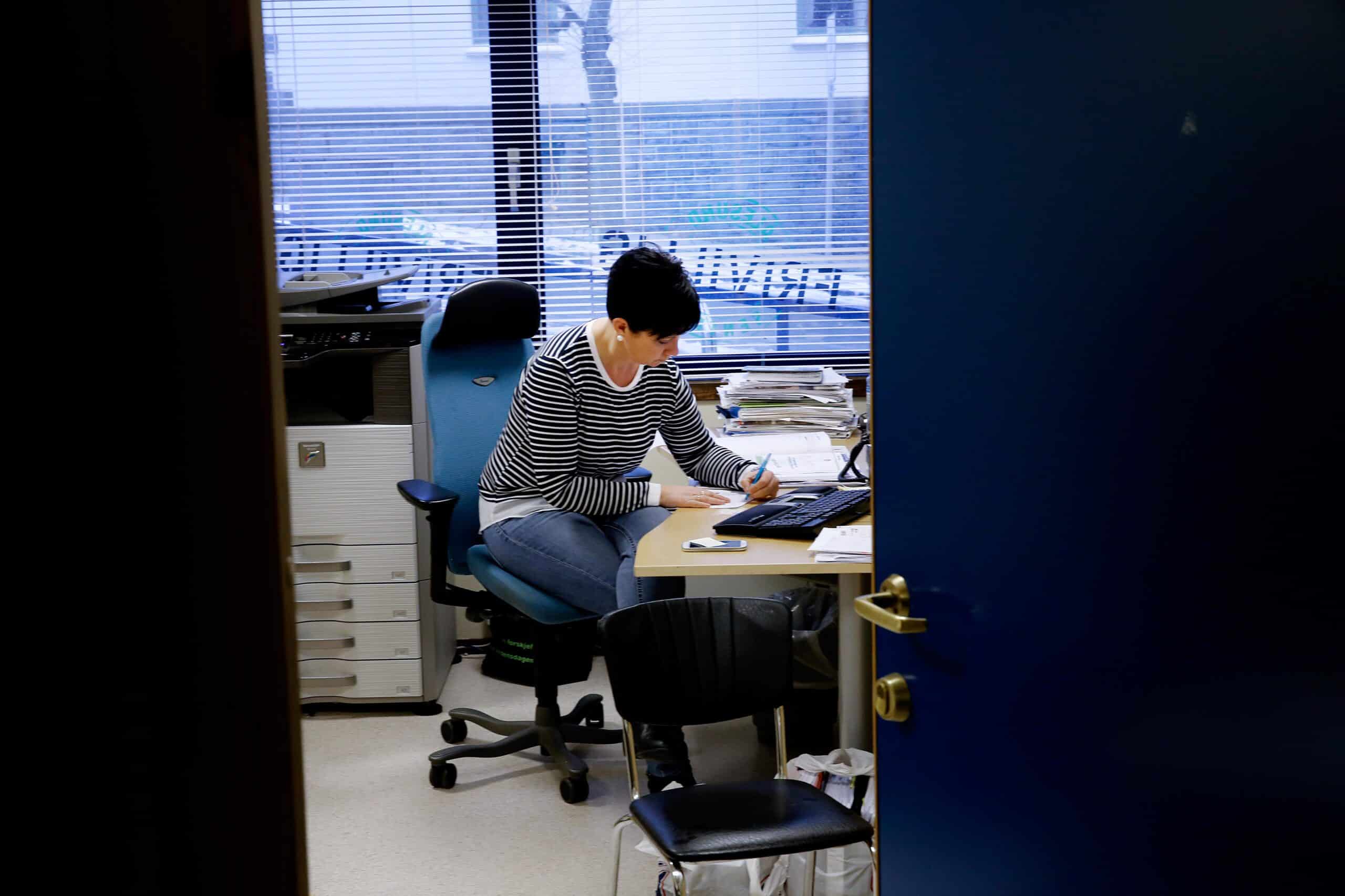en kvinne som sitter ved et skrivebord på et kontor.