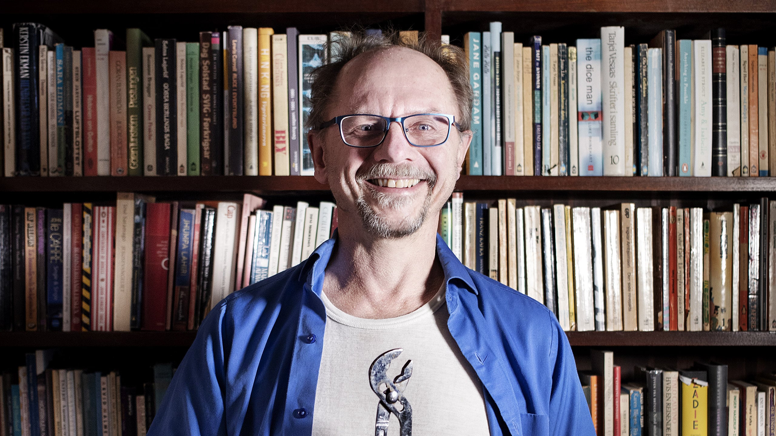 Professor Runar Døving foran en bokhylle full av bøker.