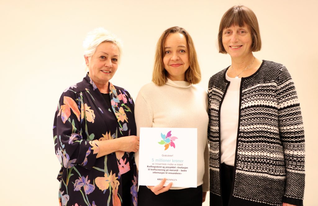 Anne Lise Ryel overrekker det synlige beviset på at prosjektet "Invitasjon til kreftscreening på morsmål – bedre informasjon til innvandrere" mottar støtte fra Kreftforeningen. Foto.