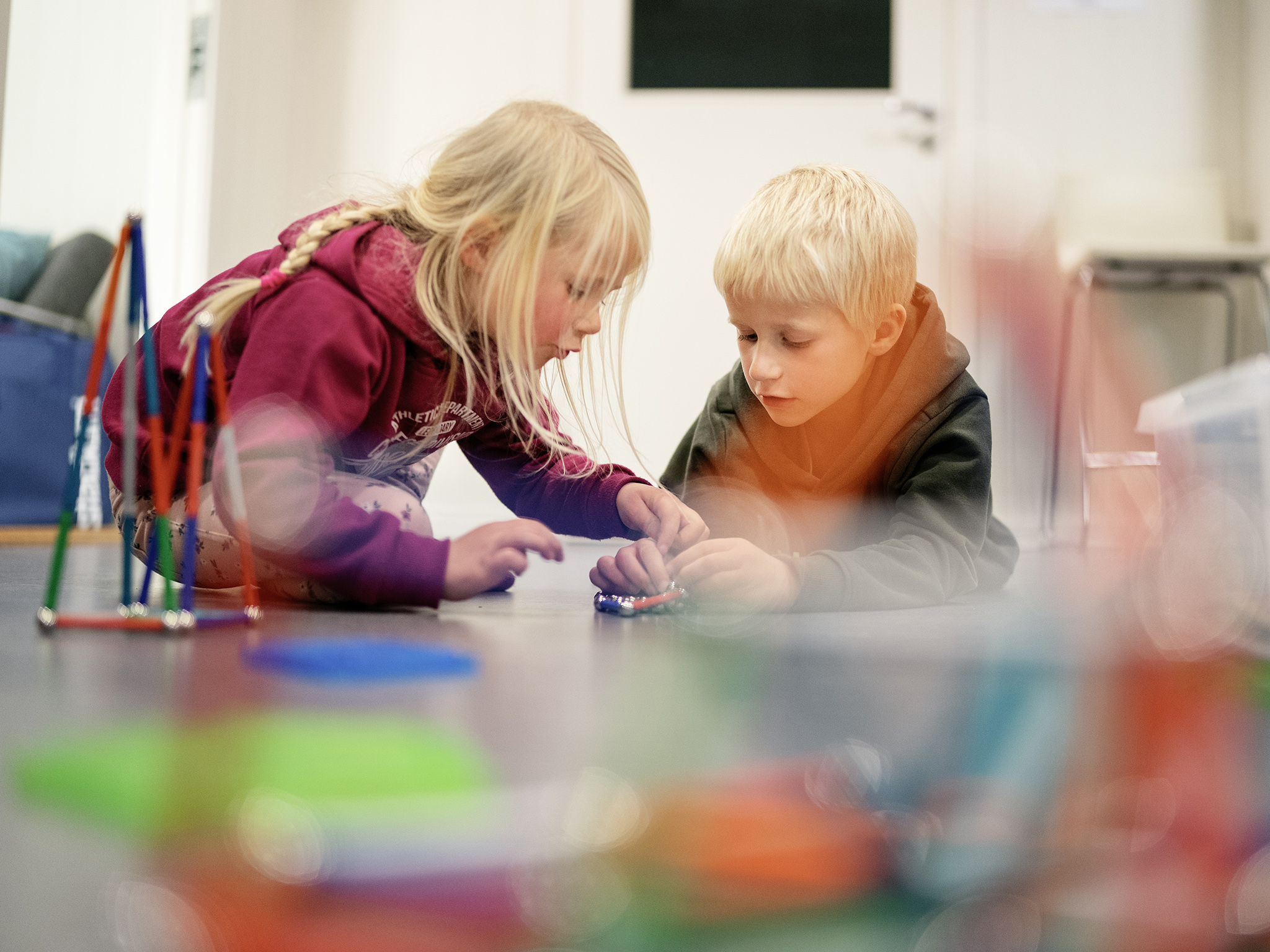 En gutt og en jente leker med magnetiske kuler og pinner.