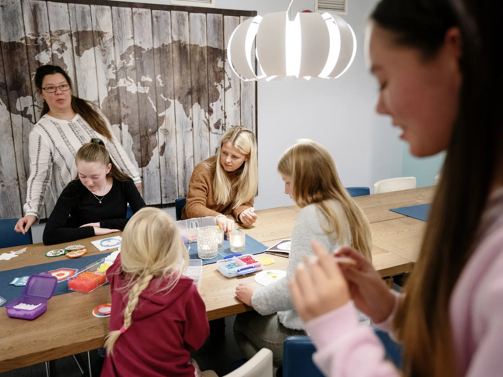 Barn og voksne leker med perler.