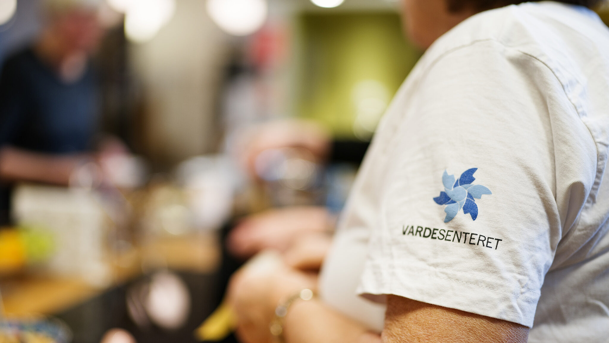 Nærbilde av en t-skjorte med Vardesenteret-logo.