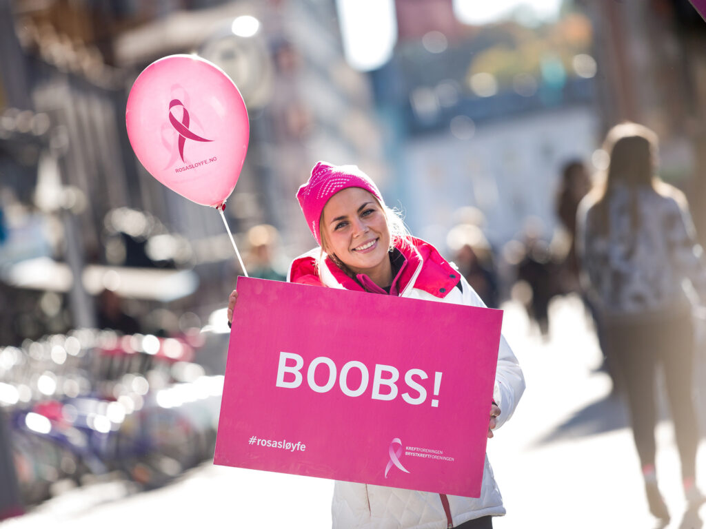Ung kvinne holder en plakat med Boobs på