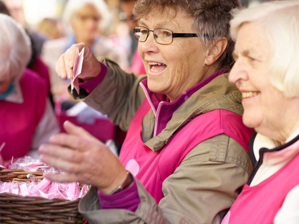 Eldre kvinner selger rosa sløyfer