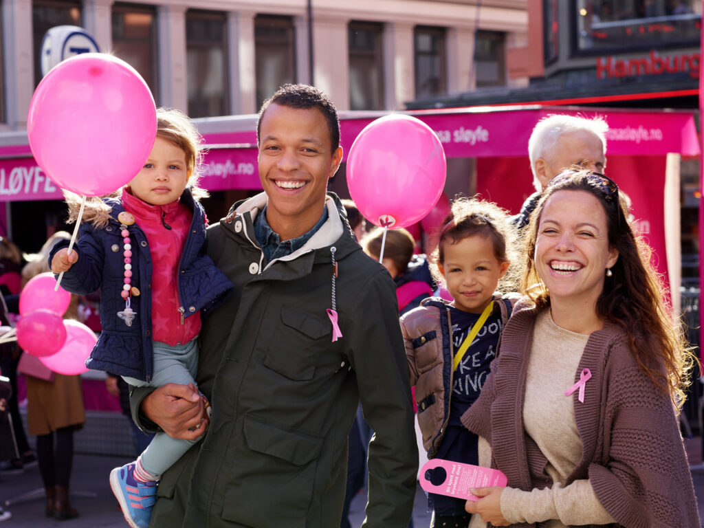 En familie med rosa ballonger.