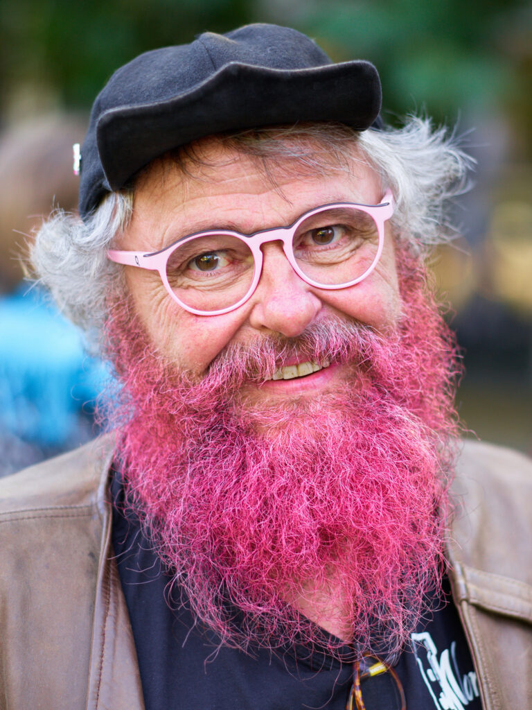 Mann med rosa skjegg og rosa briller.