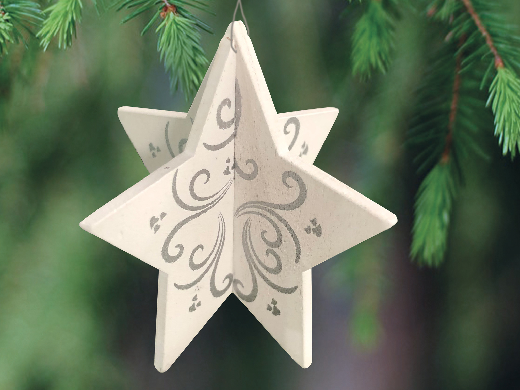 et stjernepynt i tre som henger fra et tre.