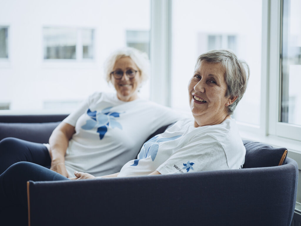 to eldre kvinner som sitter på en sofa ved siden av hverandre.