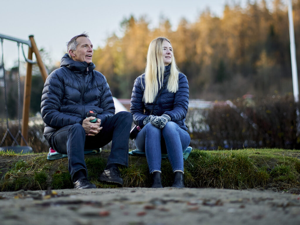 Høst. En mann og en kvinne sitter i finværet og ser utover.