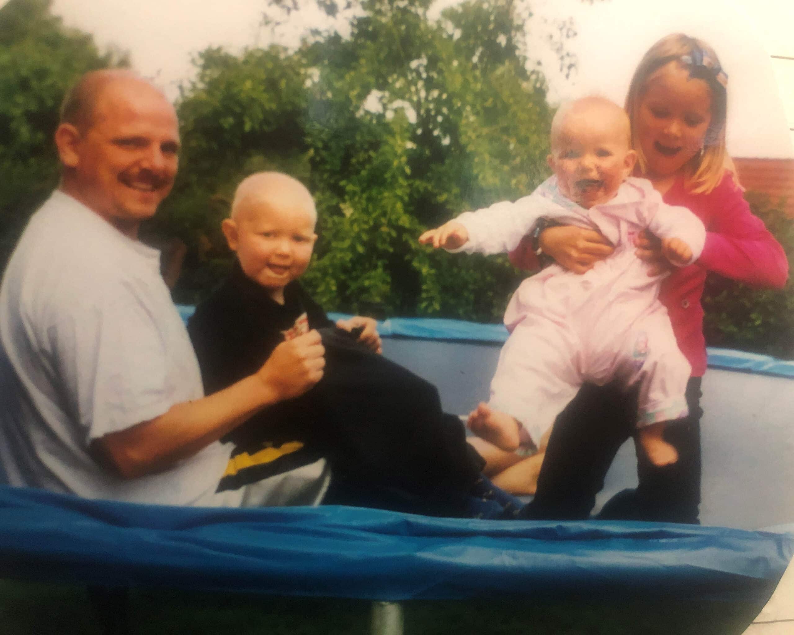 en familie som poserer på en trampoline.