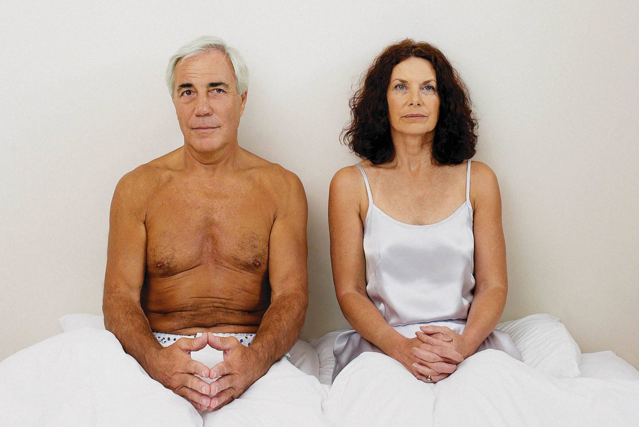 en mann og en kvinne sitter på en seng.