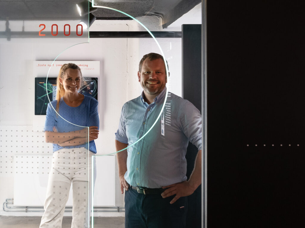 en mann og en kvinne som står bak en glassvegg