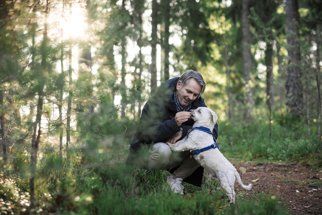 Glenn leker med hunden sin Junior i skogen.