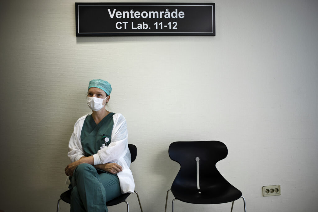 en person som sitter i en stol med en kirurgisk maske.