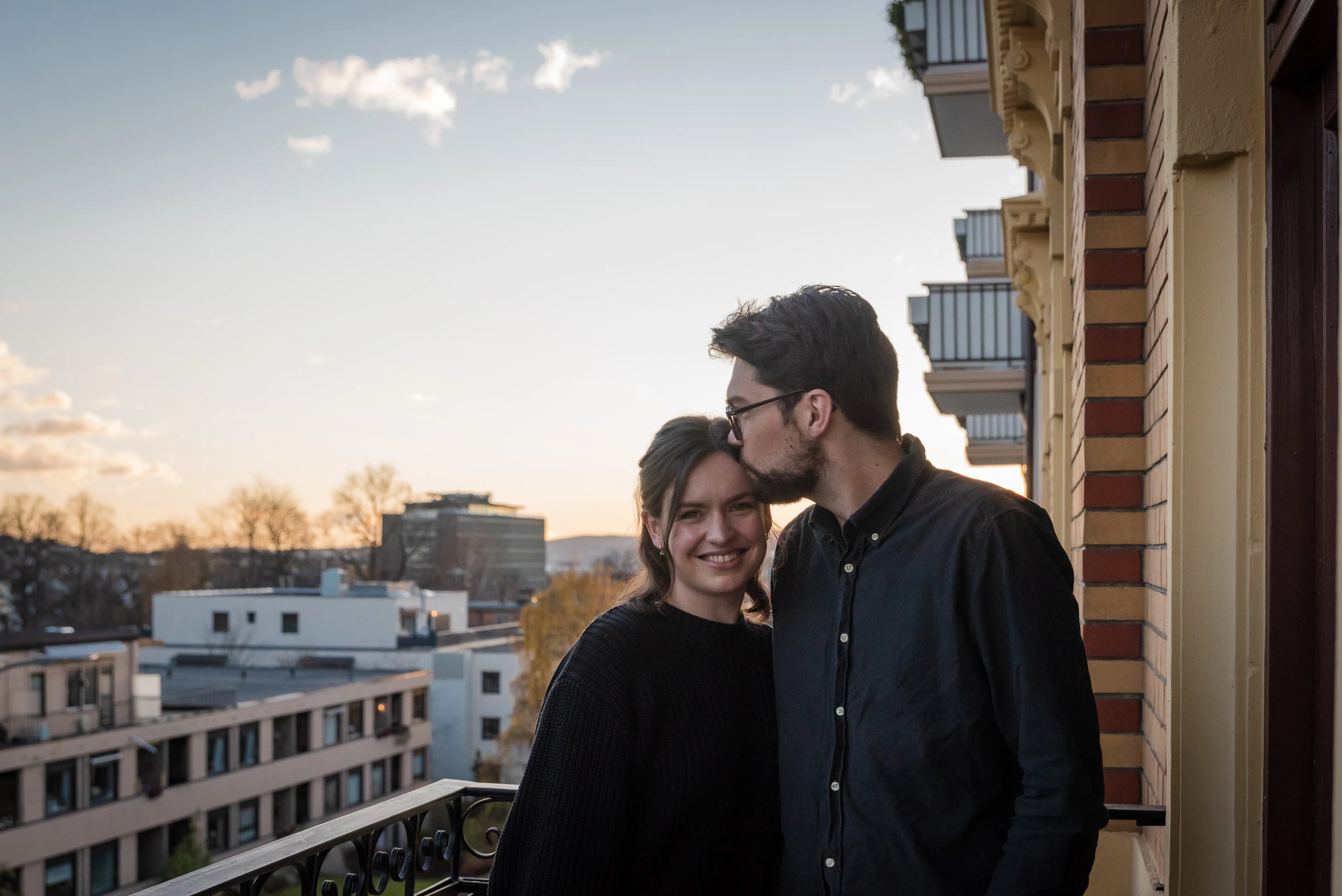 en mann og en kvinne som står ved siden av hverandre på en balkong.