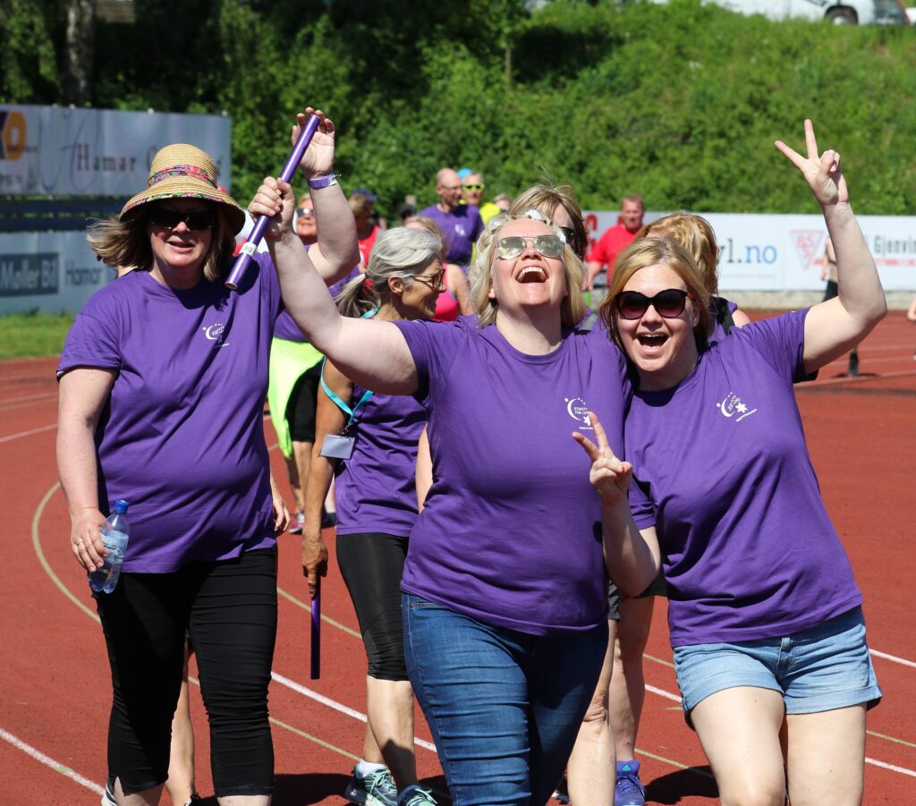 en gruppe kvinner i lilla skjorter på en løpebane