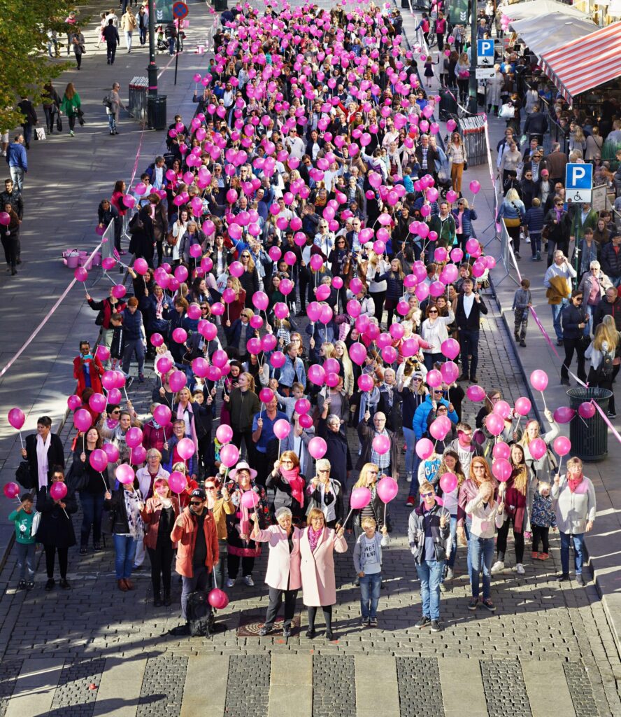 Folkemengde med rosa ballonger