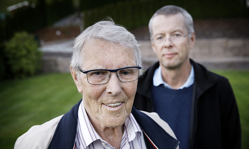 en eldre person med briller som står ved siden av en yngre mann.
