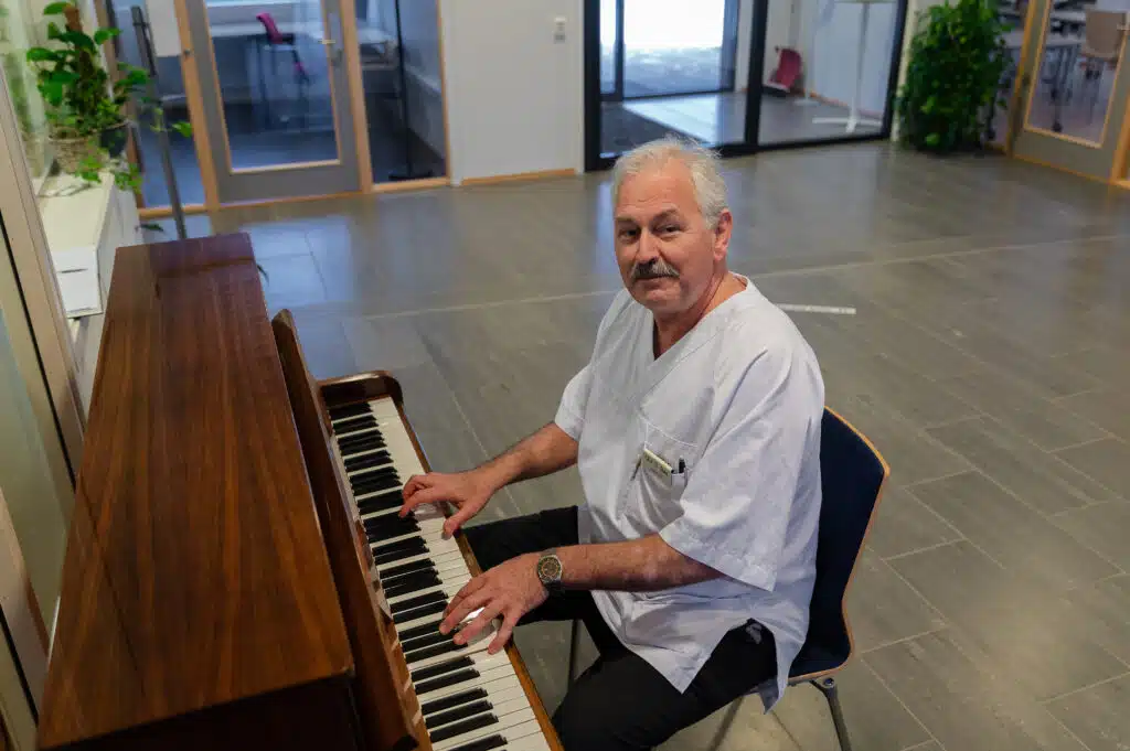 Oluf D Røesitter ved et piano