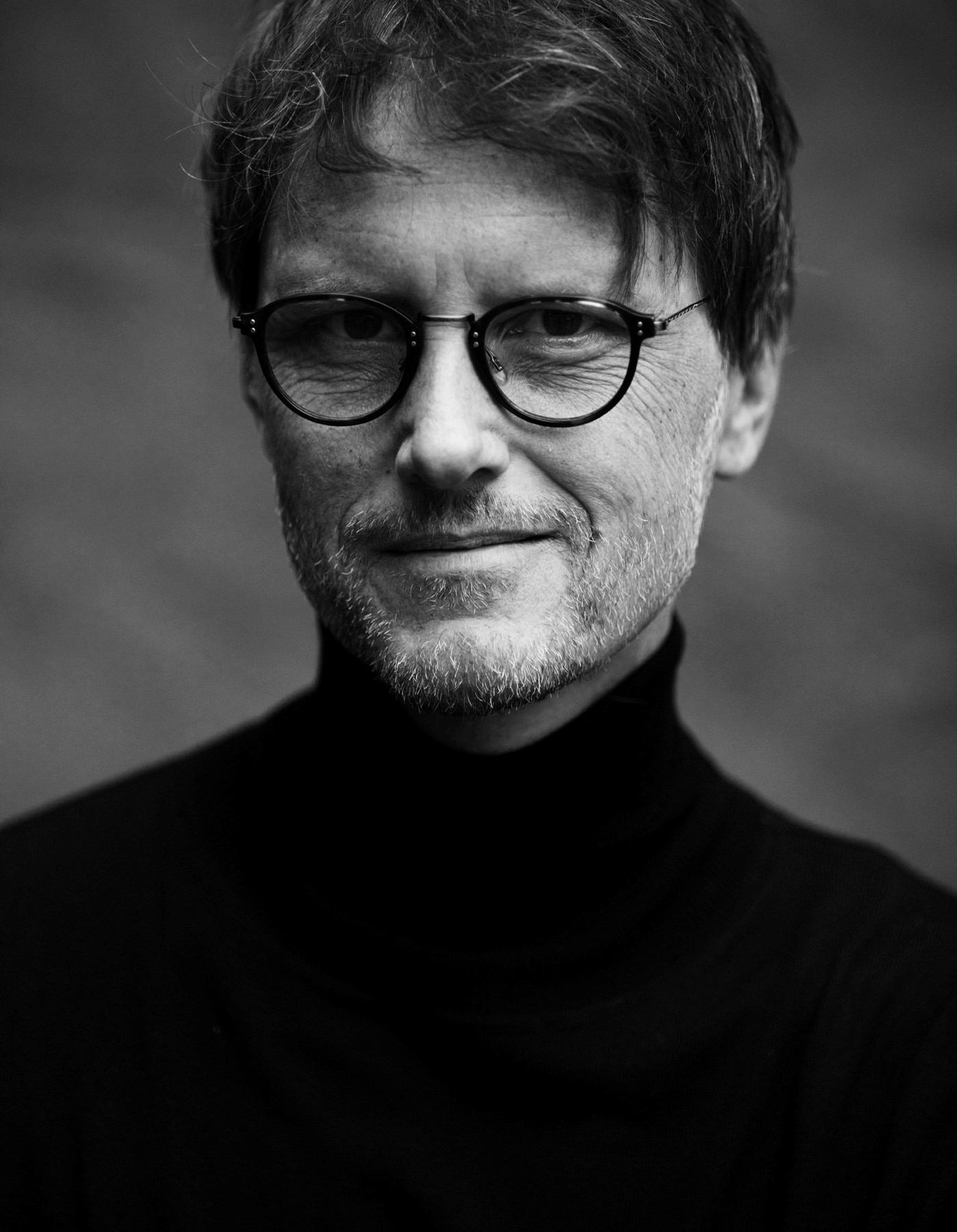 et svart-hvitt-bilde av en mann med briller.