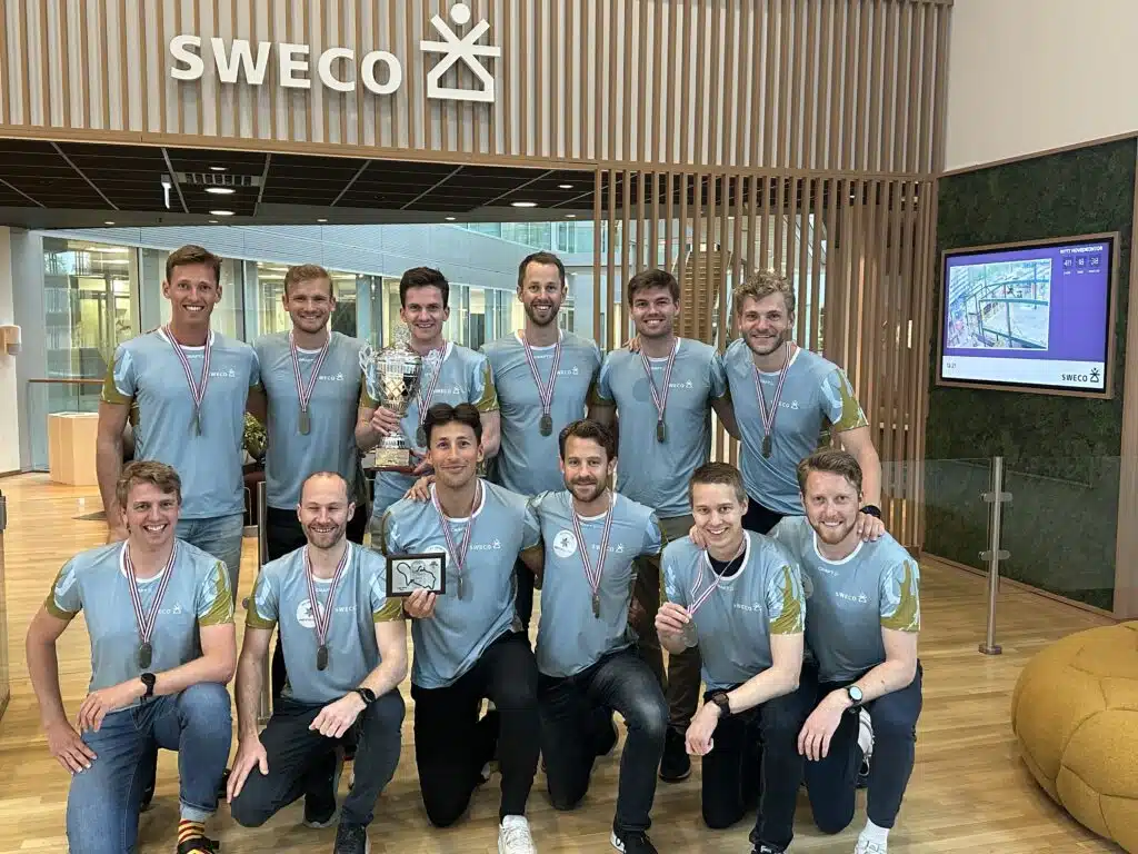 en gruppe menn som står ved siden av hverandre på et hardt tregulv.