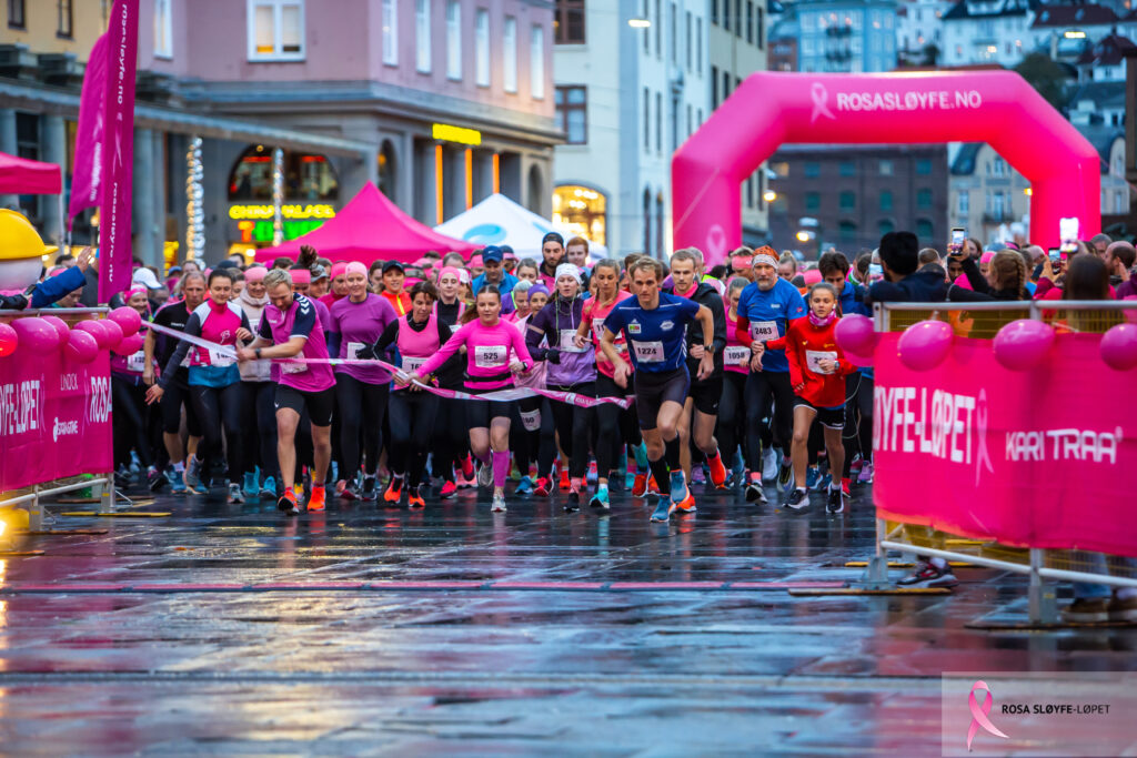 En gruppe mennesker som løper i et rosa løp.
