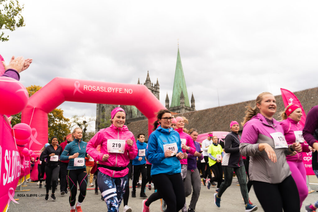 En gruppe mennesker som løper i et rosa løp.