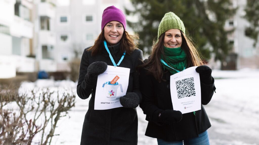 To kvinner som holder opp qr-koder i snøen.