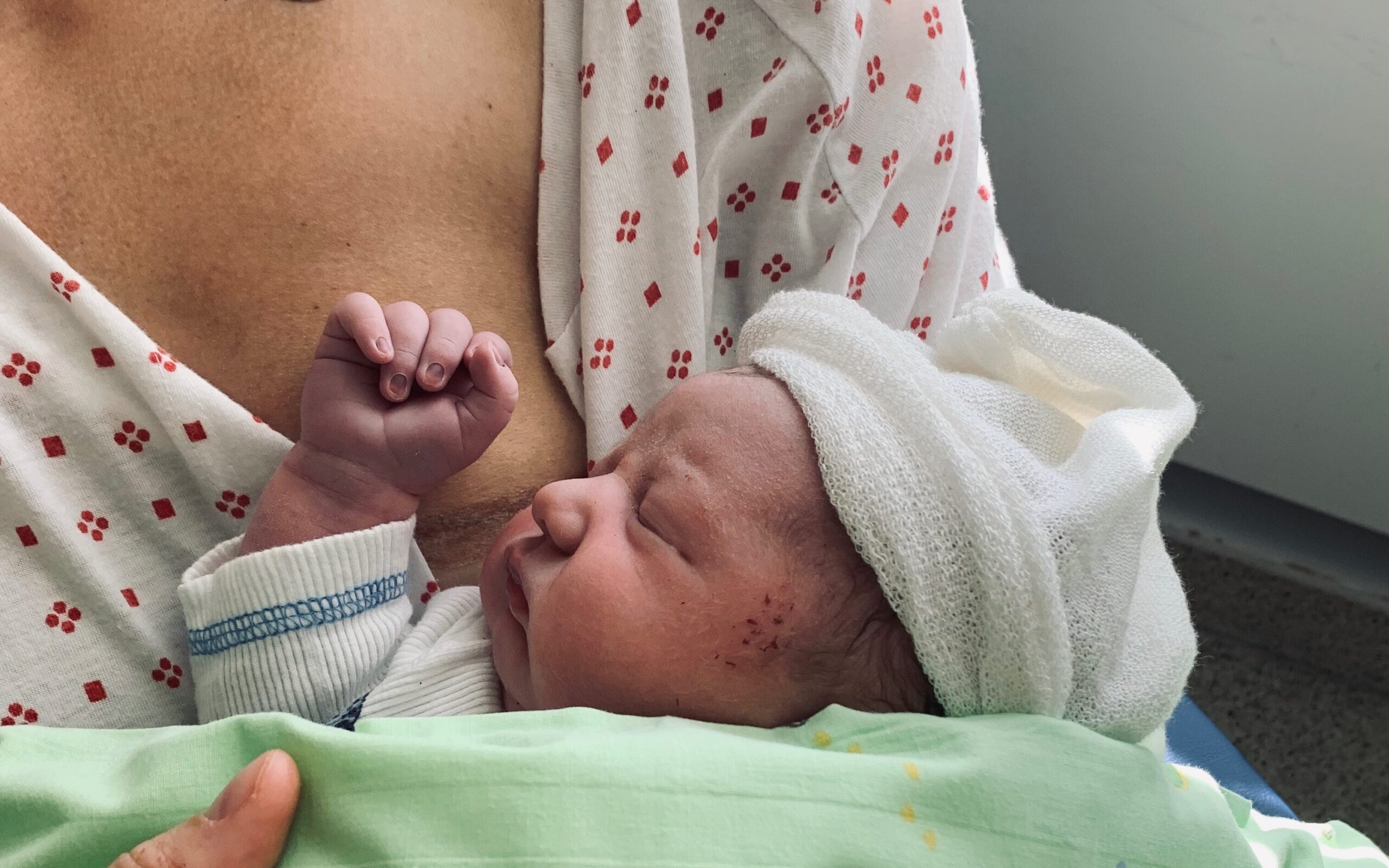 En kvinne holder en baby i en sykehusseng.