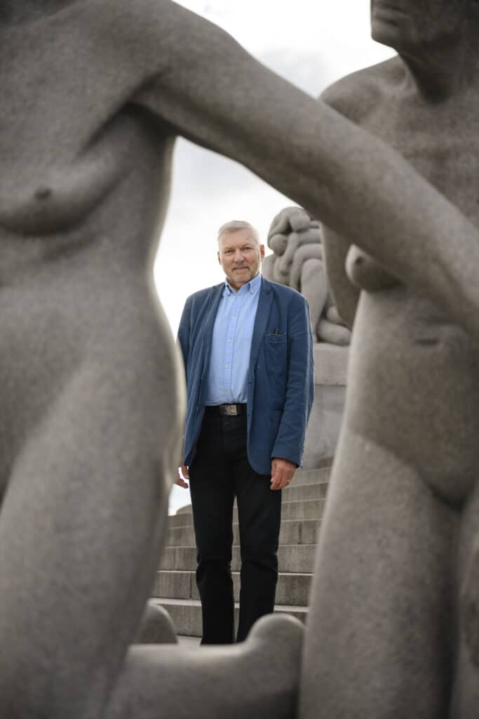 En mann som står foran statuer.