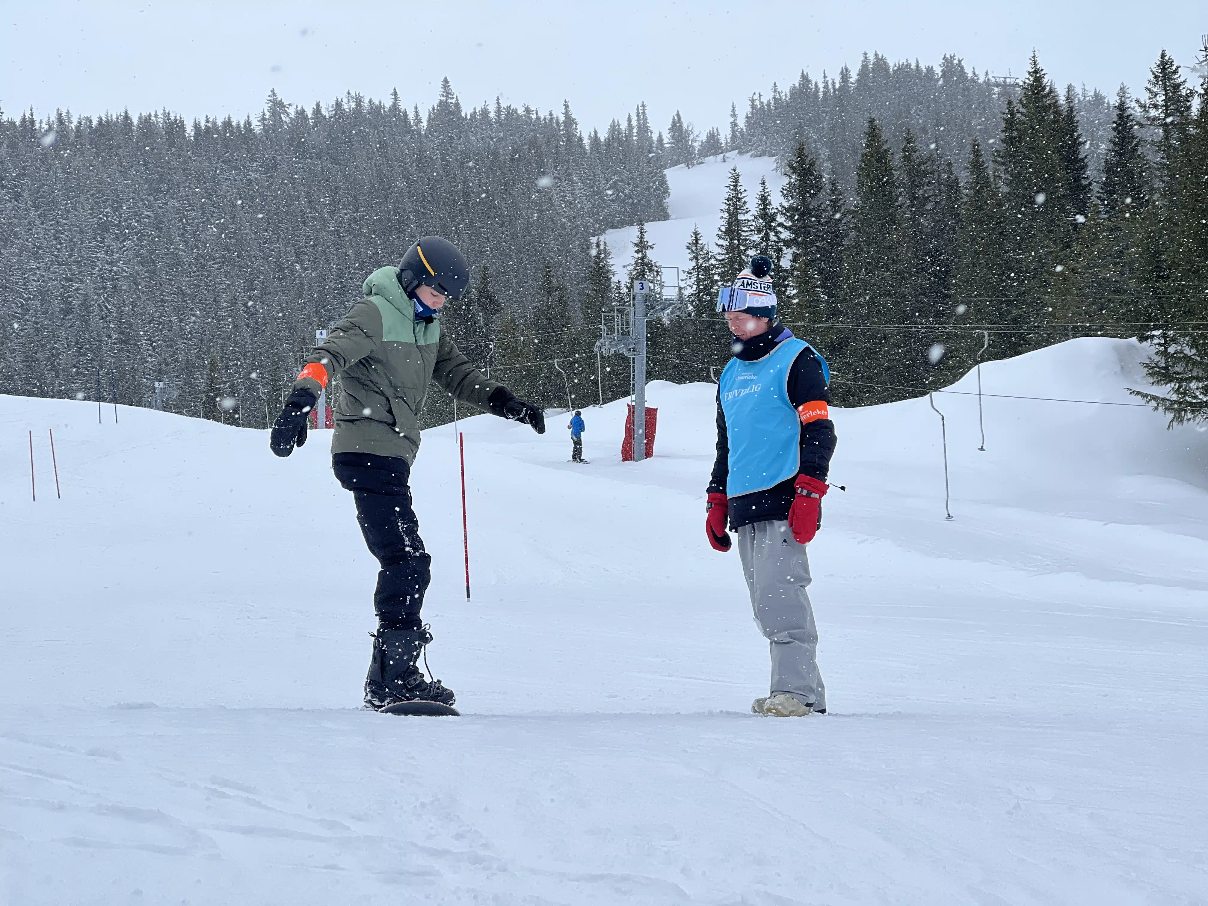 To personer på ski i en snødekt skråning.