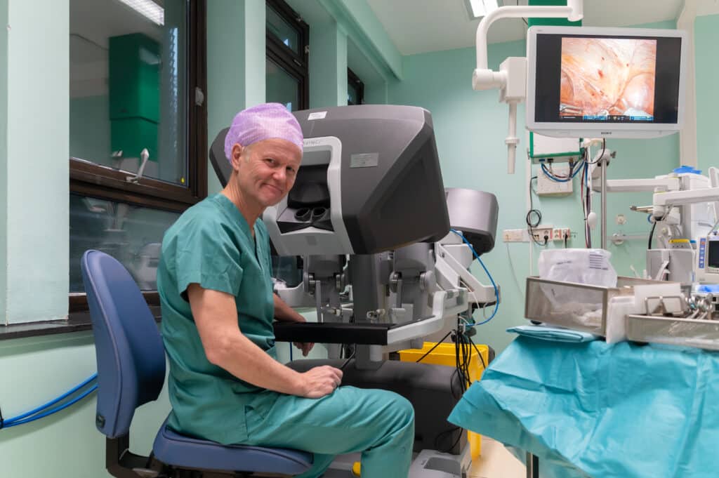 En mann i skrubber sitter på en operasjonsstue.