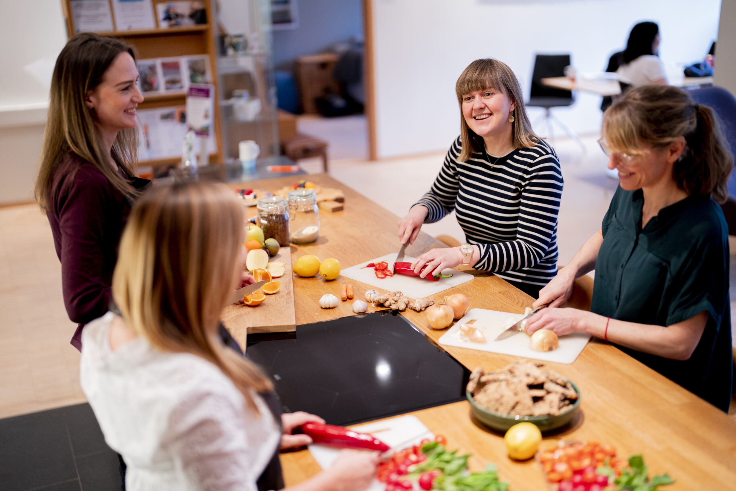 En gruppe kvinner lager mat på et kjøkken.