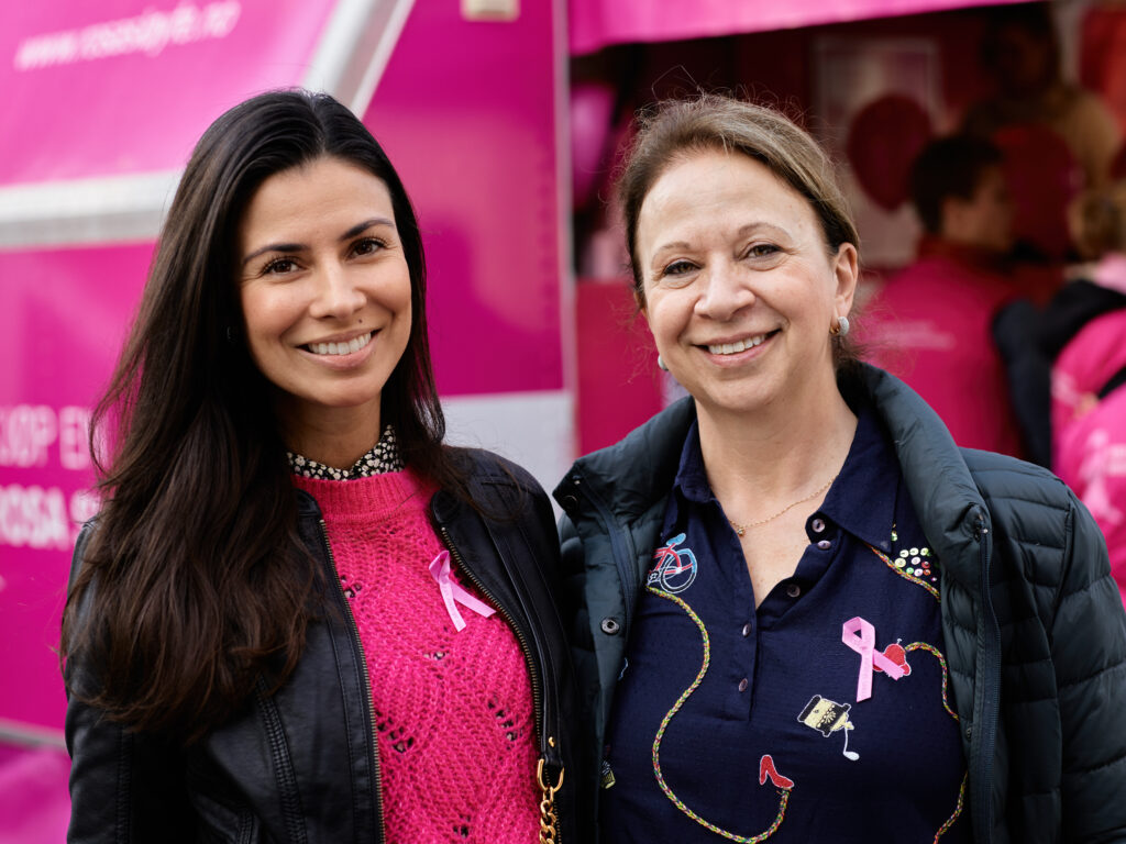 To kvinner som står foran en rosa lastebil.