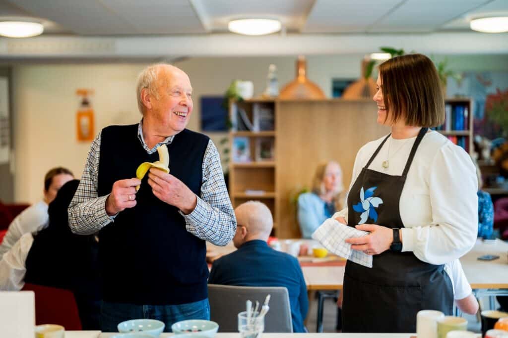 En eldre mann som smiler til en kvinne som har på seg et forkle