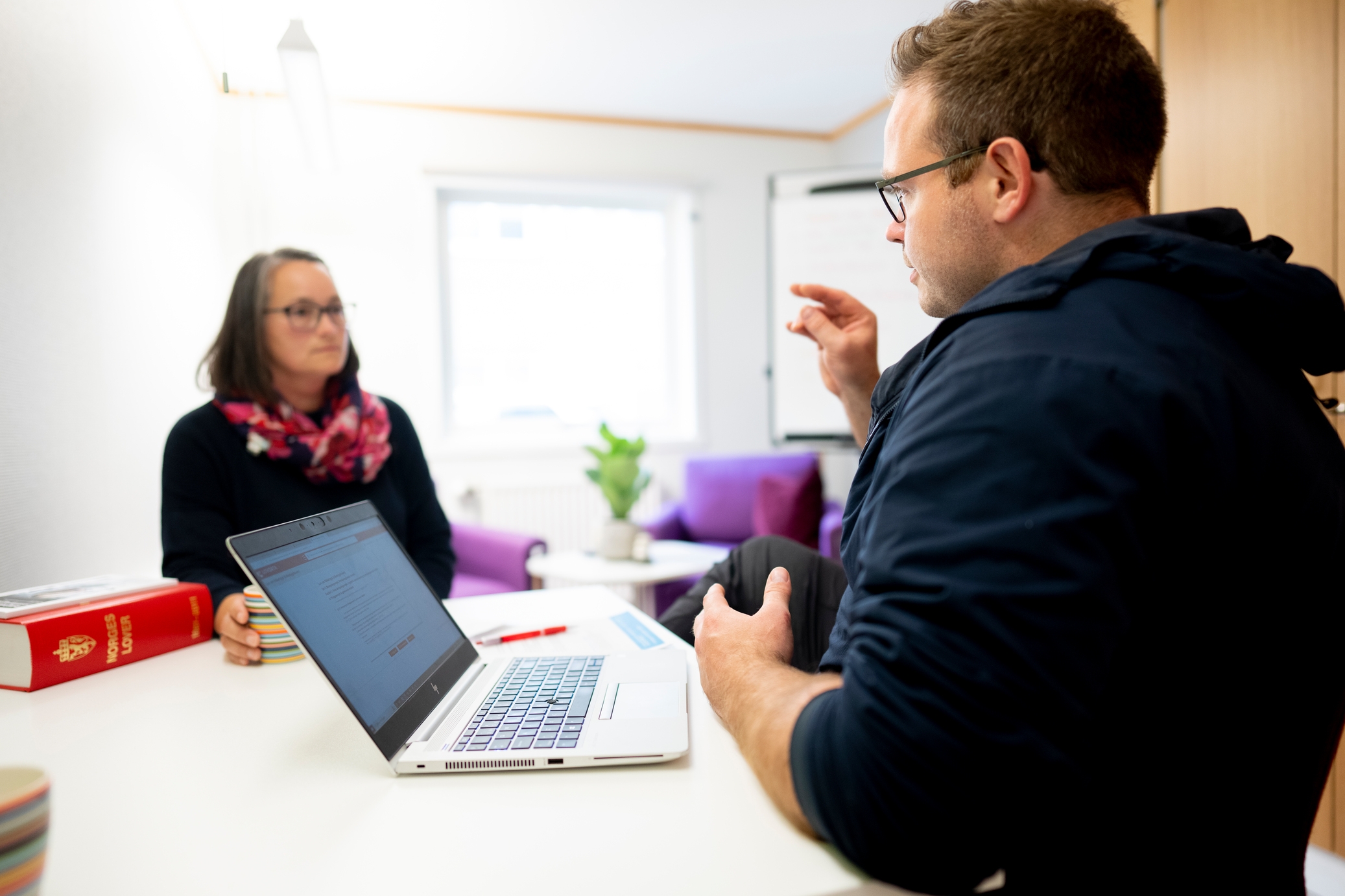 To personer har en samtale på et kontor.