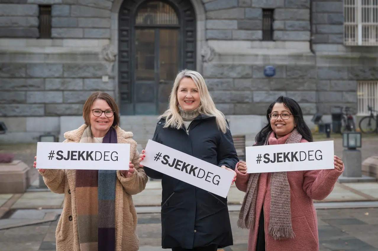 Tre personer som holder skilt med hashtaggen #SJEKKDEG