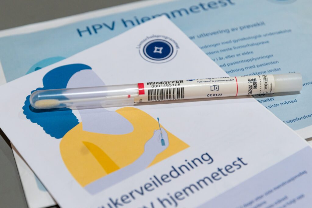 HPV hjemmetestsett med en forseglet vattpinne på toppen av et instruksjonshefte på norsk.