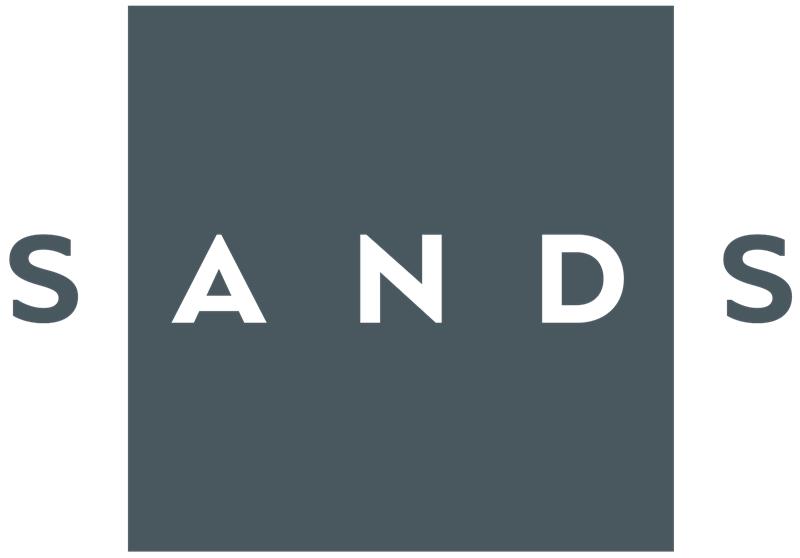 Ordet «SANDS» vises med hvite store bokstaver, med «A N D» inni en stor grå firkant og «S» på hver side utenfor firkanten.