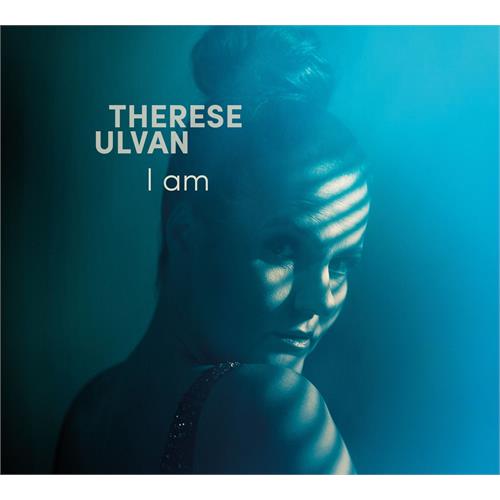 Albumomslag til «I am» av Therese Ulvan med en kvinne i blått lys med skyggestriper og albumtittel og artistnavn i fet skrift.