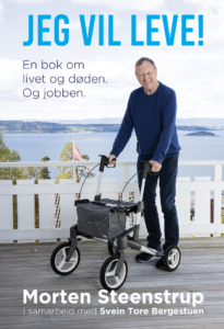 En eldre mann står på en veranda med en rullator og smiler til kameraet. Bak ham er det en innsjø og åser. Tekst på bildet reklamerer for en bok med tittelen «Jeg vil leve!» av Morten Steenstrup.