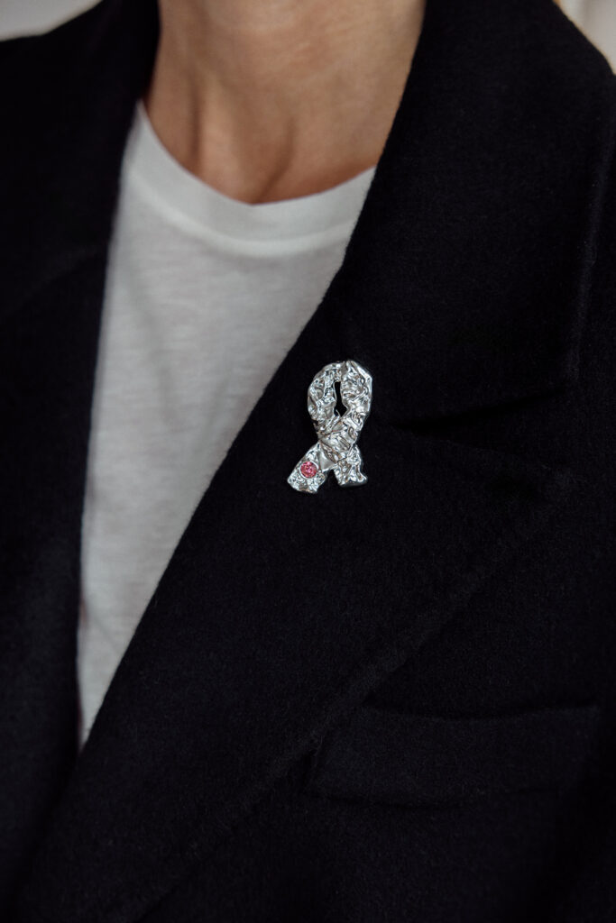 Årets Rosa sløyfe på en kvinne med svart blazer.og en hvit t-skjorte