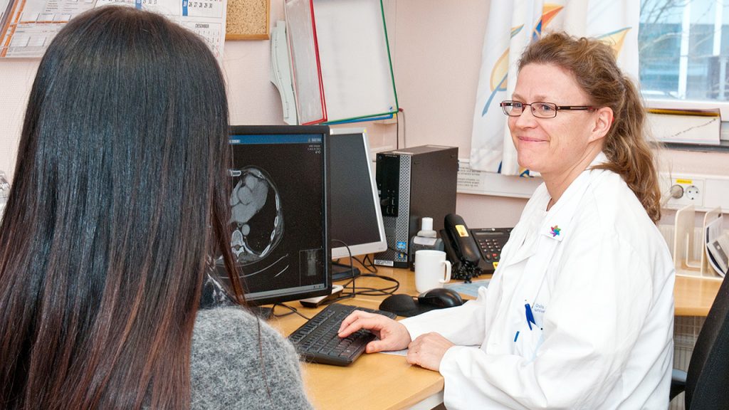 Lungekreftlege Åslaug Helland ved Radiumhospitalet i samtale med en pasient. Foto.
