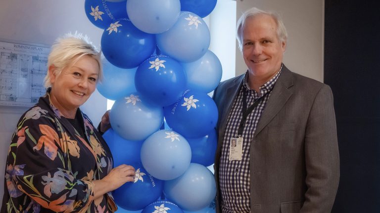 Anne Lise Ryel og Sigbjørn Smeland ved siden av ballonger med Vardesenterets logo. Foto.